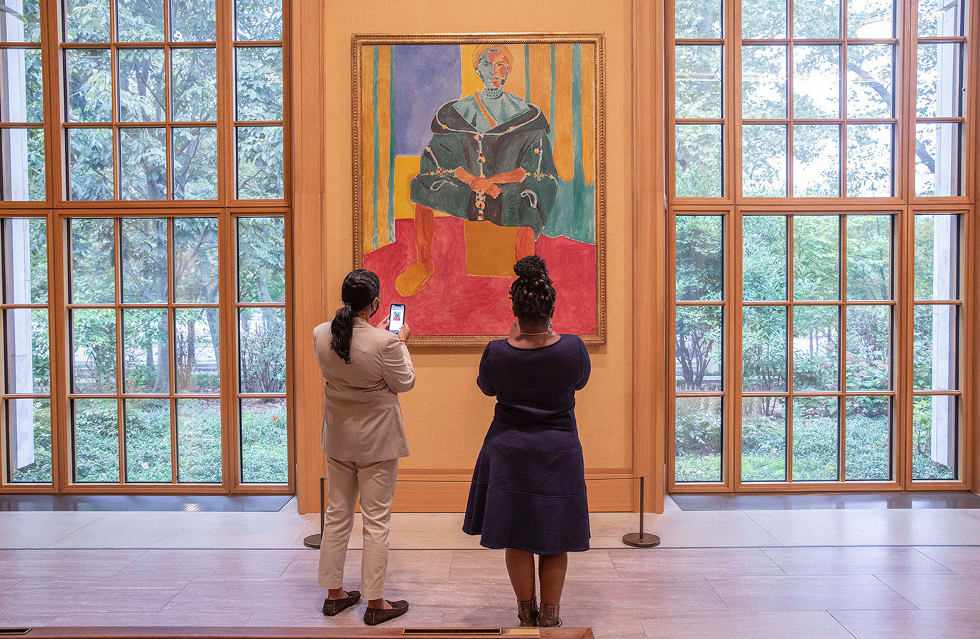 Two visitors taking photos of a painting